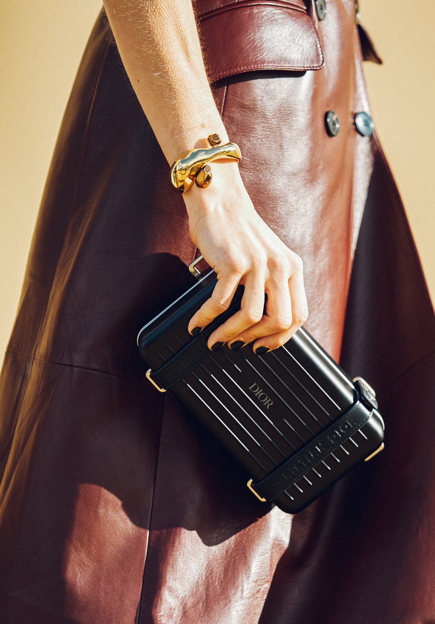 gold bracelet and Dior clutch