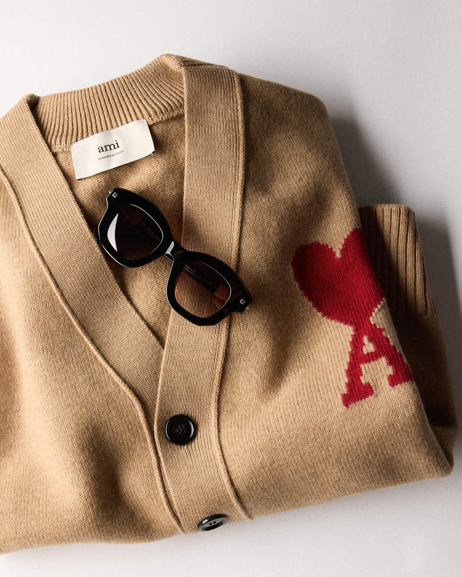 Ami Paris cardigan with black sunglasses.