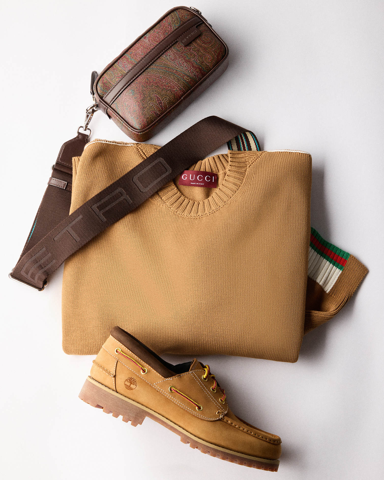Etro printed leather crossbody bag with Camel-colored Gucci crewneck sweater and Timberland Nubuck boat shoes.