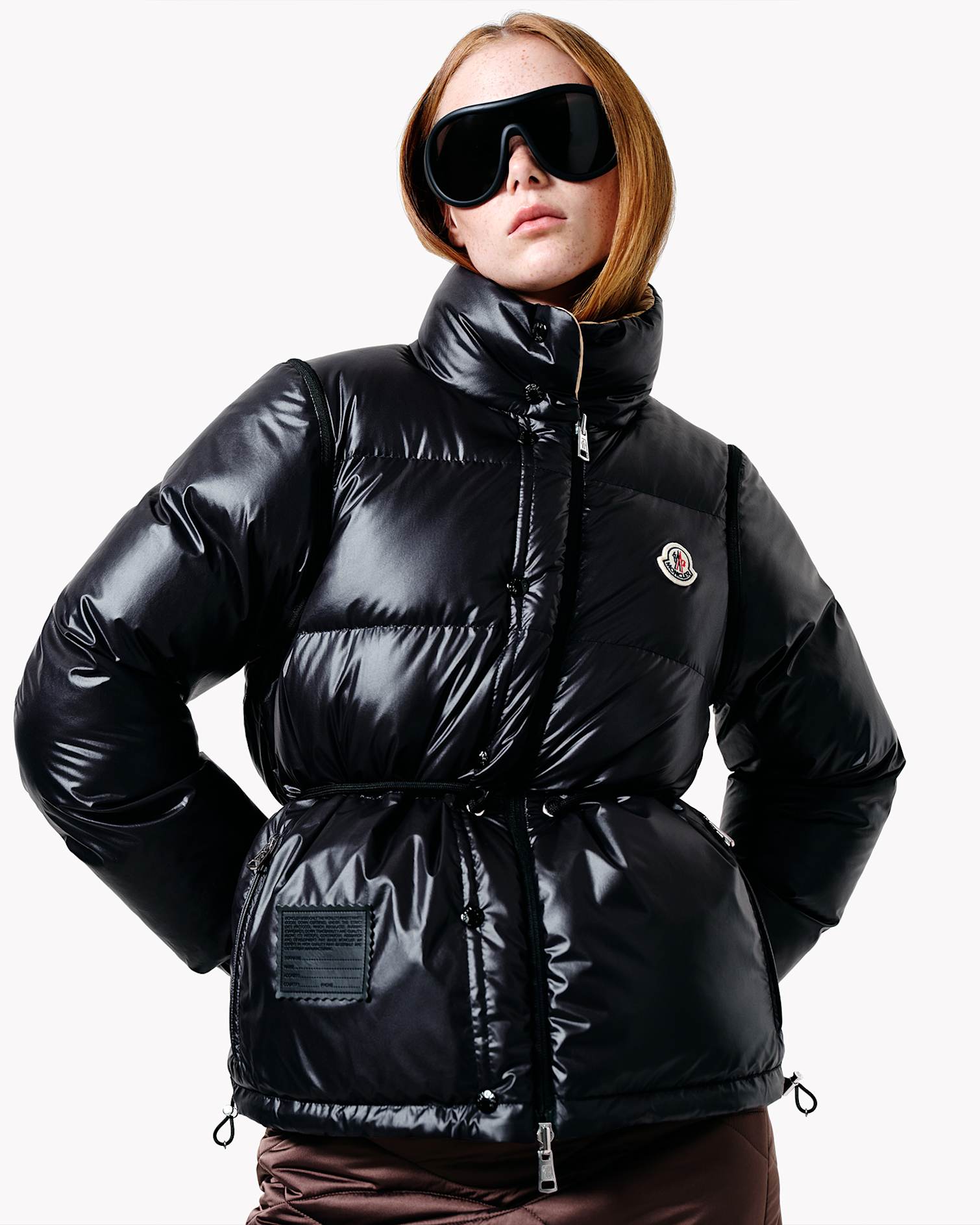 Model wears black Moncler shield sunglasses and a puffer down jacket