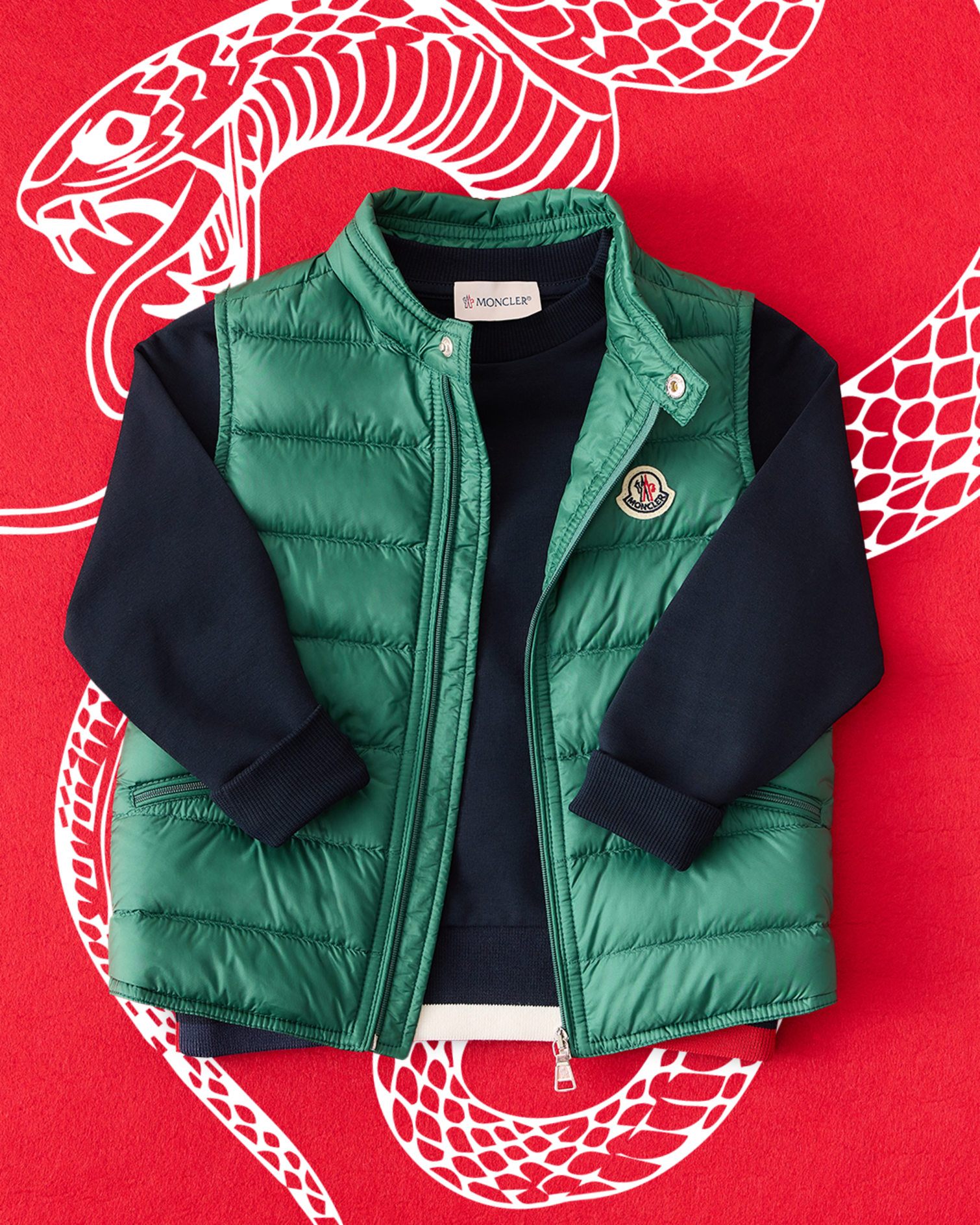 Moncler Giu packable nylon down vest in green. White snake motif on a red background.