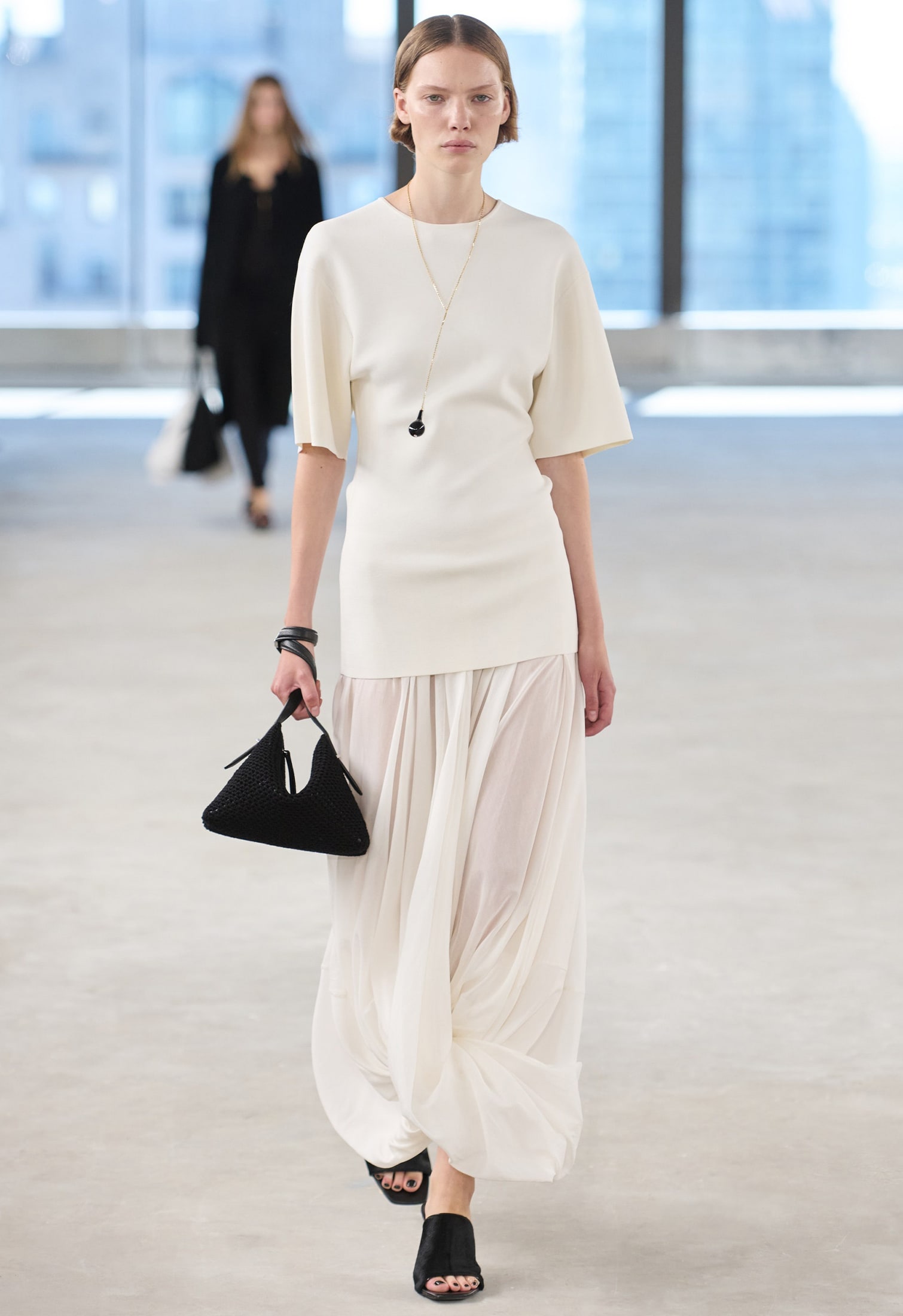 woman wearing a fitted white tee with large sleeves and black accessories