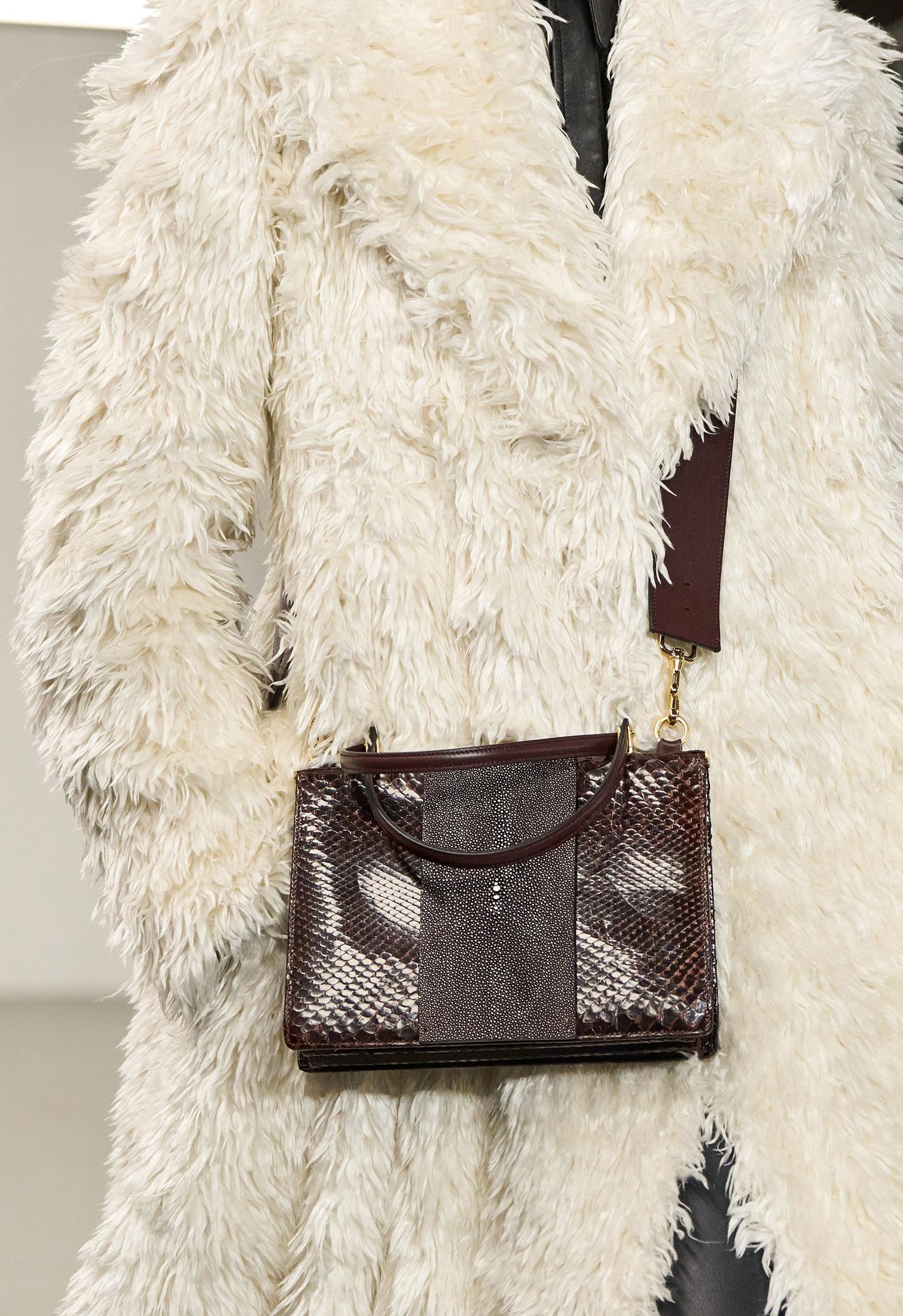 Model with brown python bag and white fur coat