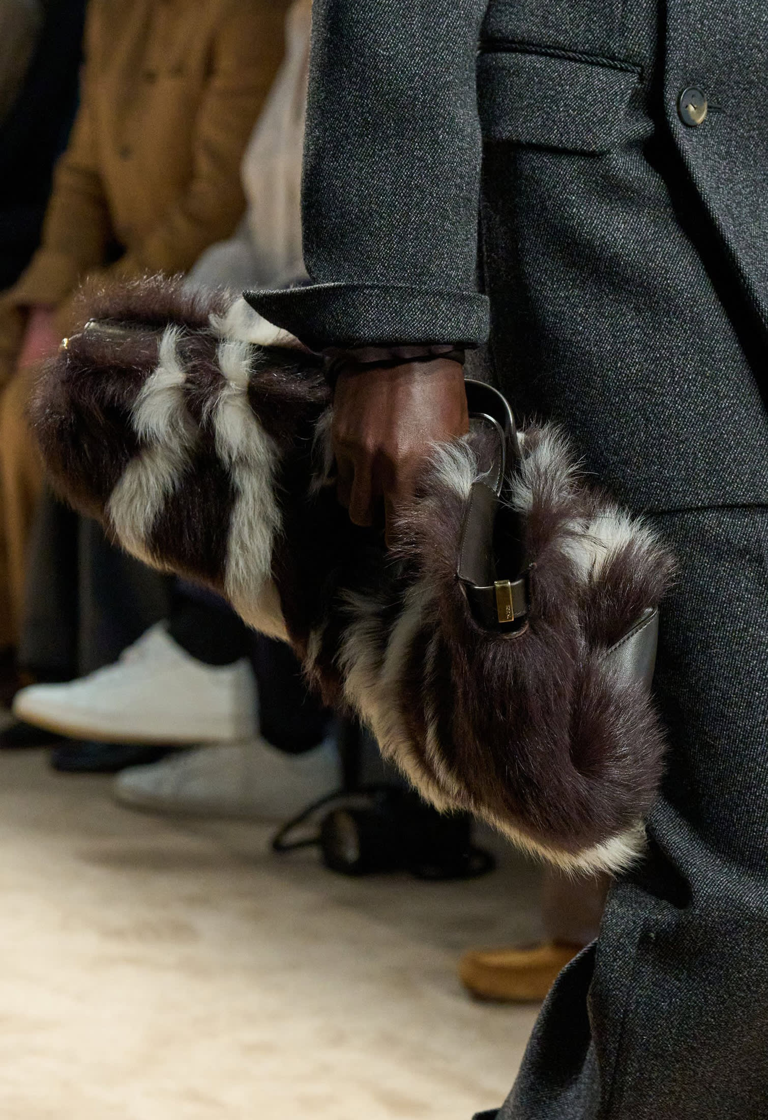 Model with grey coat and maxi fur clutch