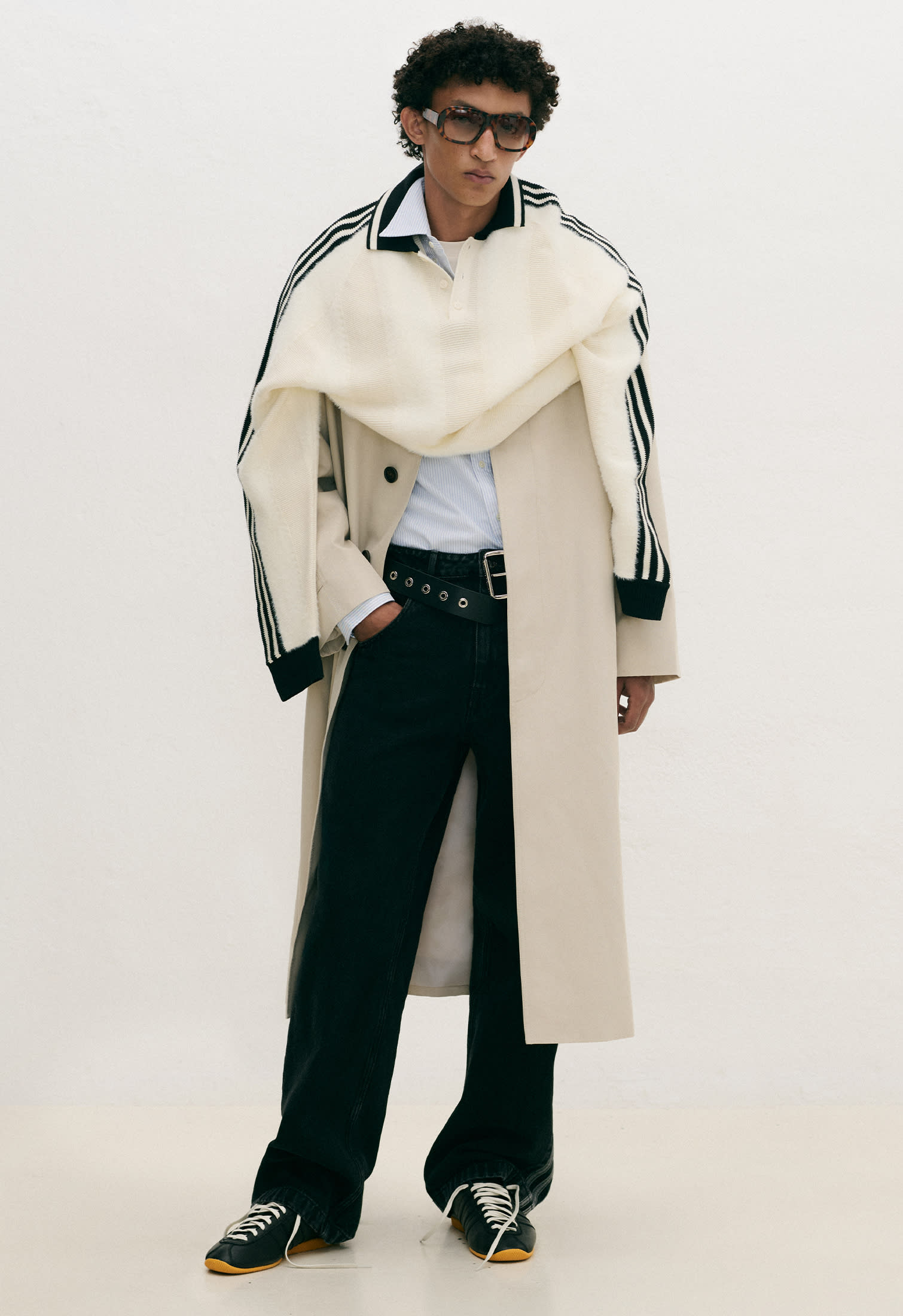 Man wearing white sweater and dark pants with retro inspired sneakers