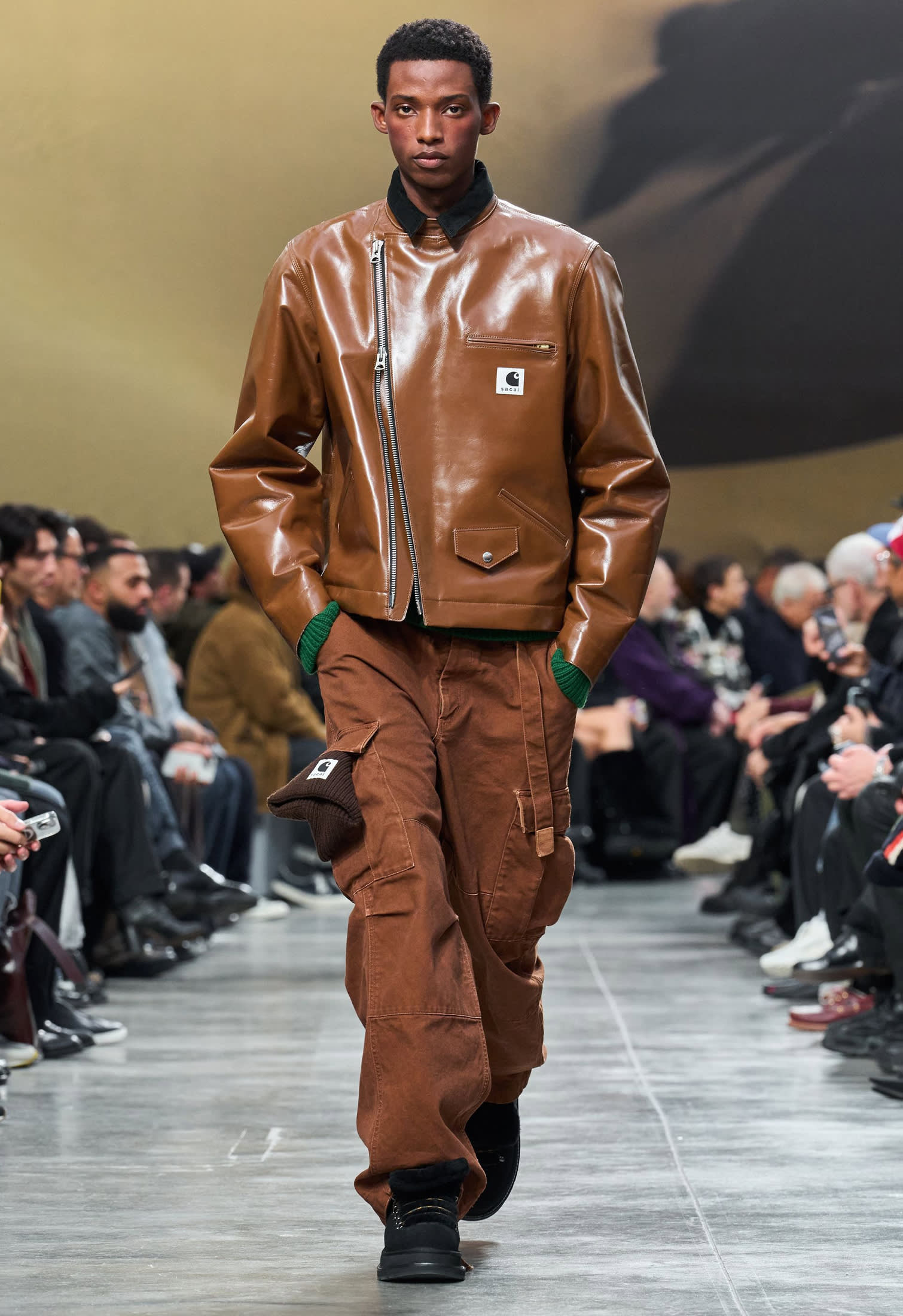 Male model wearing a brown biker leather jacket with matching trousers, modern runway style Fall Winter 2025-2026