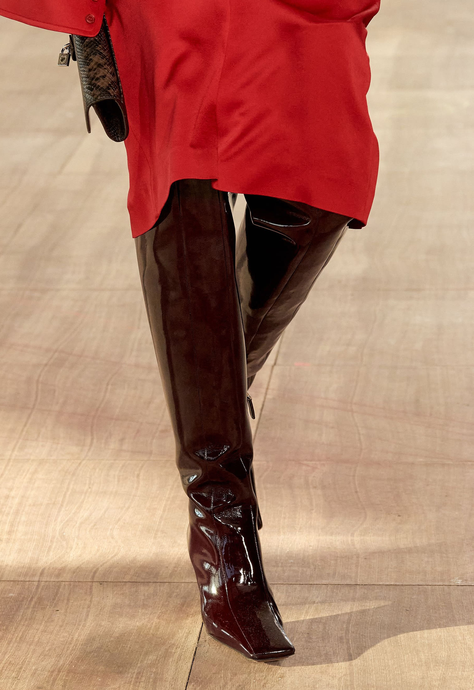 Model with over-the-knee patent brone leather boots