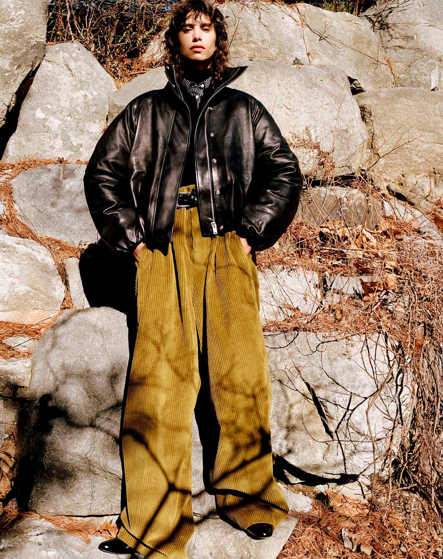 Woman wearing brown corduroy pants and black leather jacket
