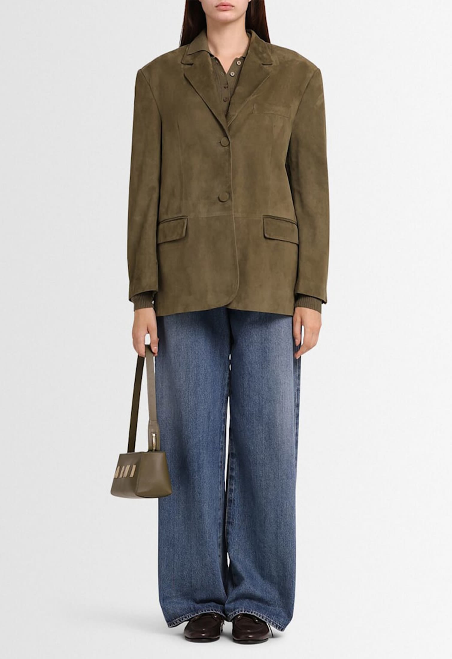 Woman wearing a tailored green leather blazer paired with wide-leg denim and handbag, casual chic outfit Fall Winter 2025-2026