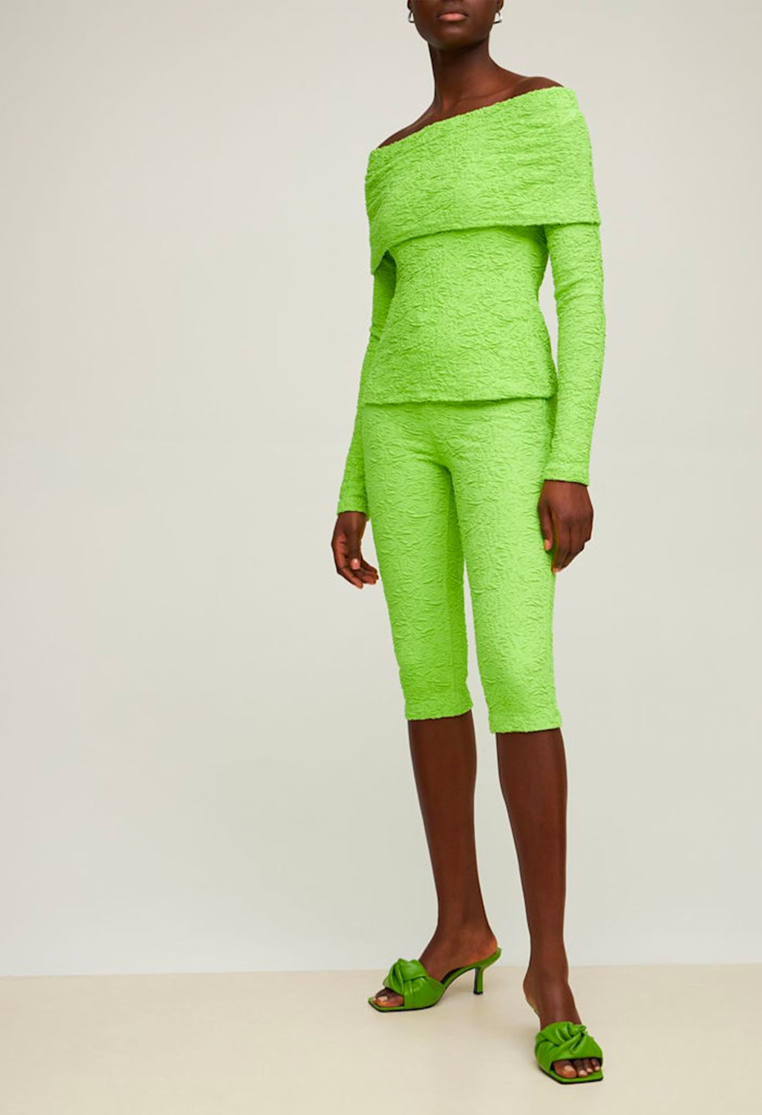 Model with neon green total look: top and shorts