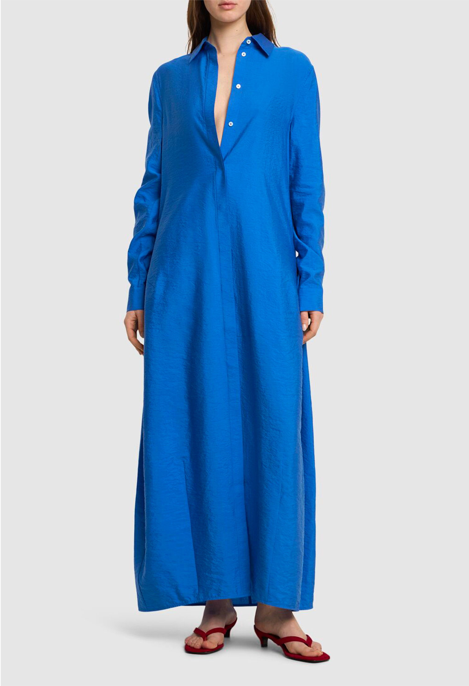 Model with Toteme parachute long blue shirt dress and red sandals