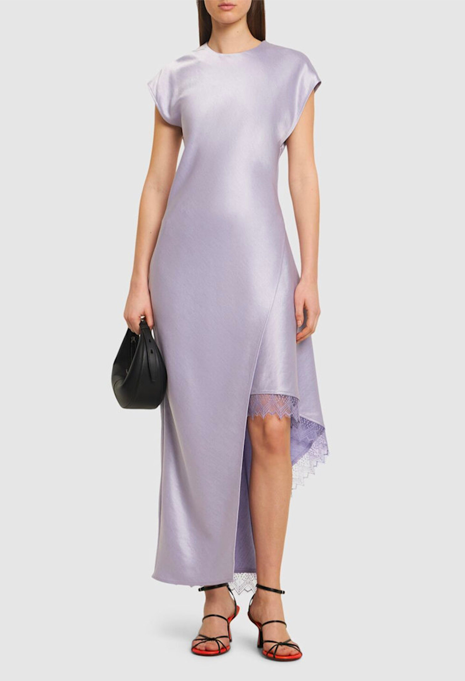 Model with JW Anderson asymmetric layered satin midi dress and black and red sandals