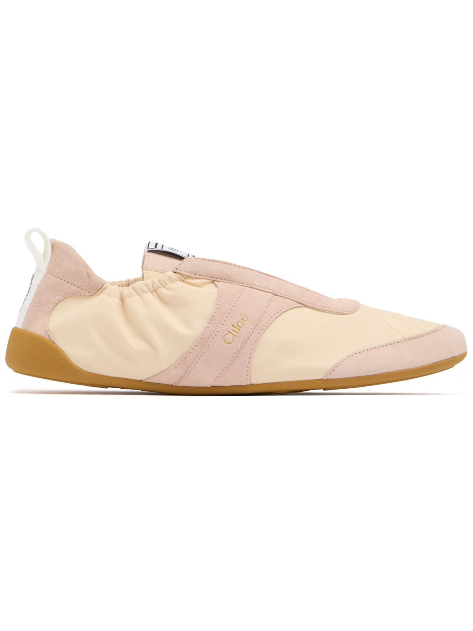 A side-profile view of a minimalist low-top sneaker in pale cream and dusty rose.